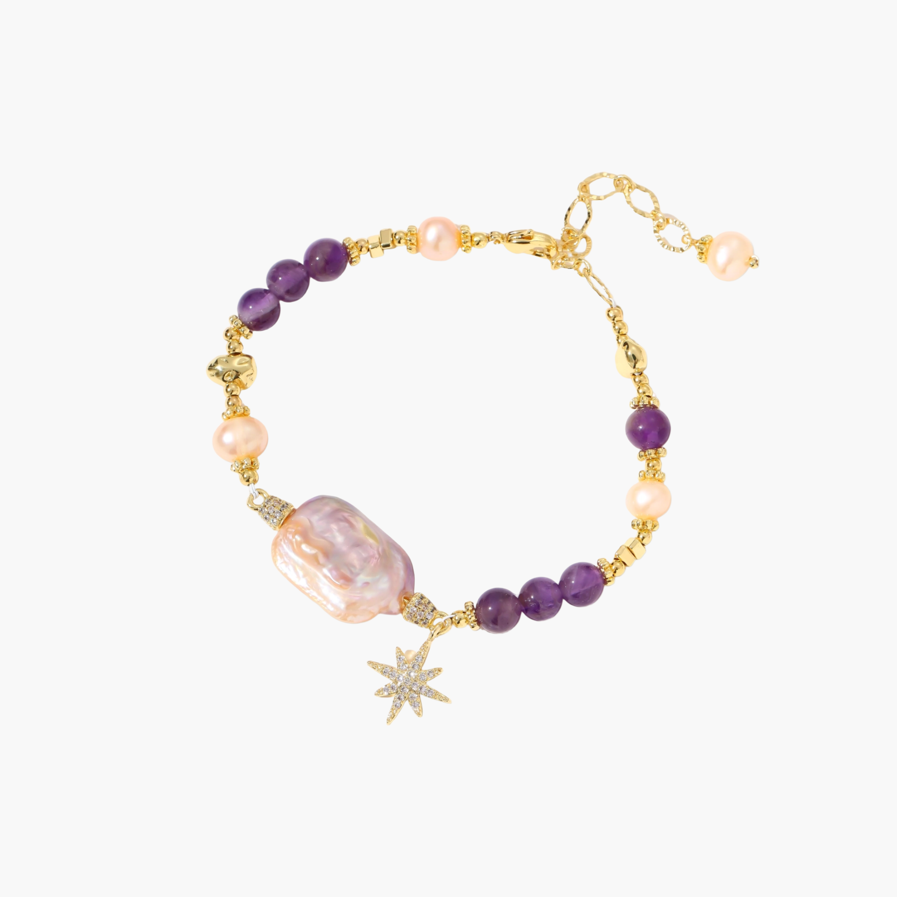 Gold-plated bracelet with baroque pearl centerpiece, amethyst beads, and crystal star charm on white background.