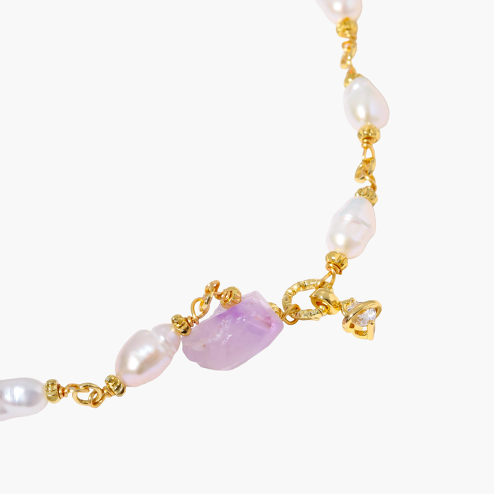 Gold-plated bracelet with lustrous baroque pearls and raw lavender amethyst centerpiece on white background.