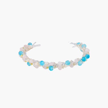 Delicate wire-wrapped bracelet featuring turquoise, rose quartz, freshwater pearls, and zircon on a white background.