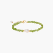 Delicate sterling silver bracelet with lime-green peridot gemstone chips and single freshwater pearl centerpiece