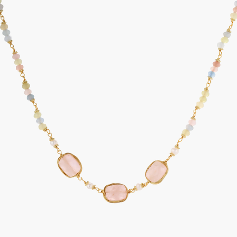 Gold necklace with three rose quartz stones, multicolor pastel beads, and pearl accents on white background.