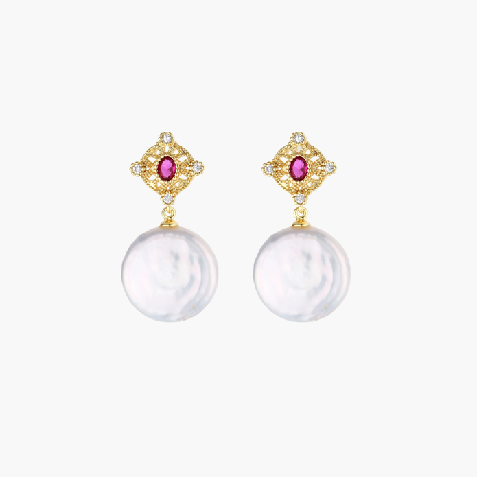 Gold baroque pearl earrings with pink gemstone studs and ornate detailing on cream background.