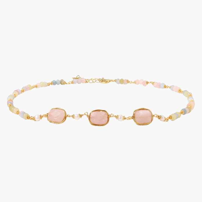 Gold necklace with three rose quartz stones, multicolor pastel beads, and pearl accents on white background.