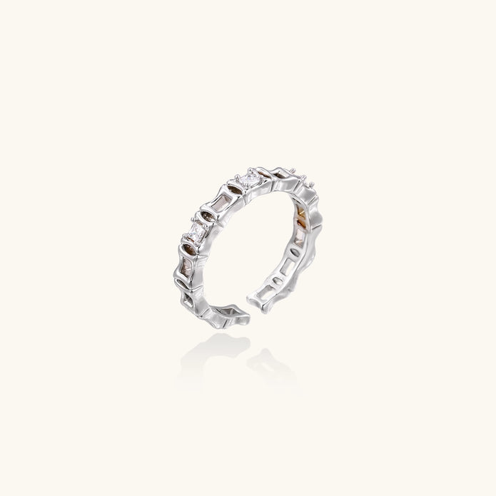 White gold plated ring with architectural lattice design and zirconia accents on cream background