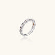 White gold plated ring with architectural lattice design and zirconia accents on cream background