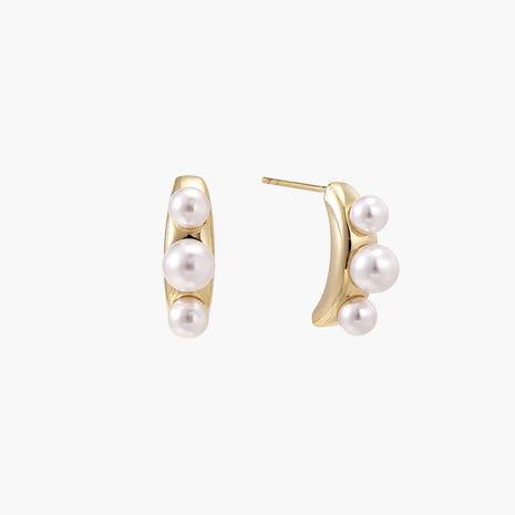 14K gold-plated curved stud earrings with three white freshwater pearls aligned vertically on cream background