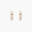 14K gold-plated curved stud earrings with three white freshwater pearls aligned vertically on cream background