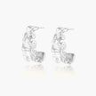 White gold plated sculptural hoop earrings with organic wavy edges and reflective metallic finish on cream background