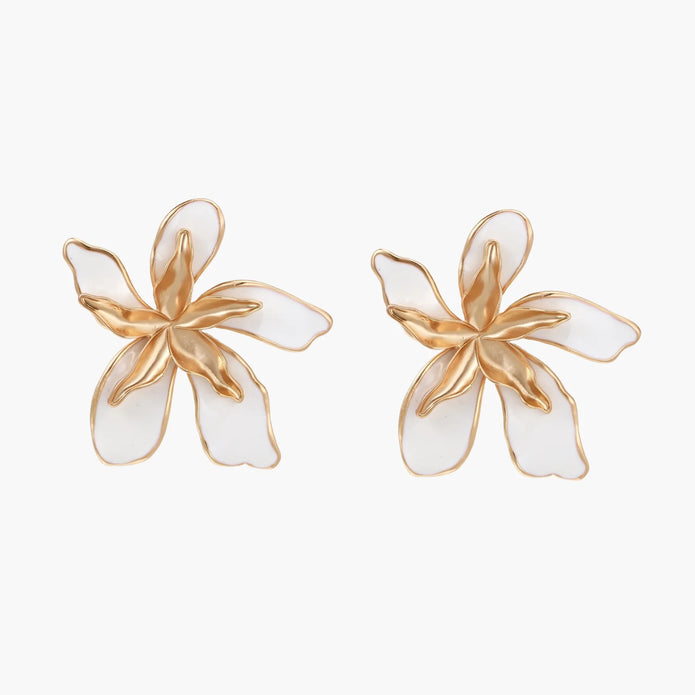 White enamel tropical flower earrings with sculptural gold-plated center and organic petal design on cream background
