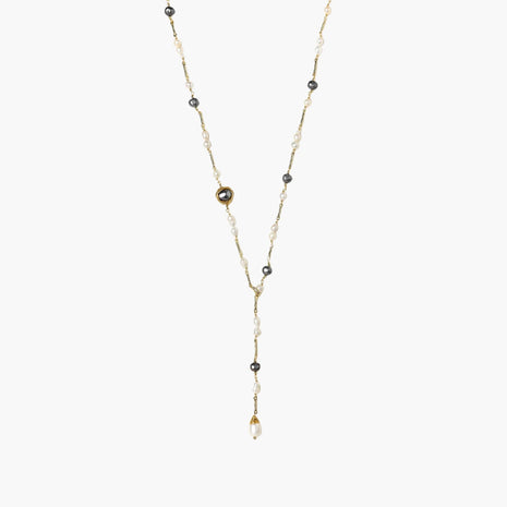 Y-shaped gold-plated necklace with white and gray freshwater pearls on cream background, showing adjustable drop design.