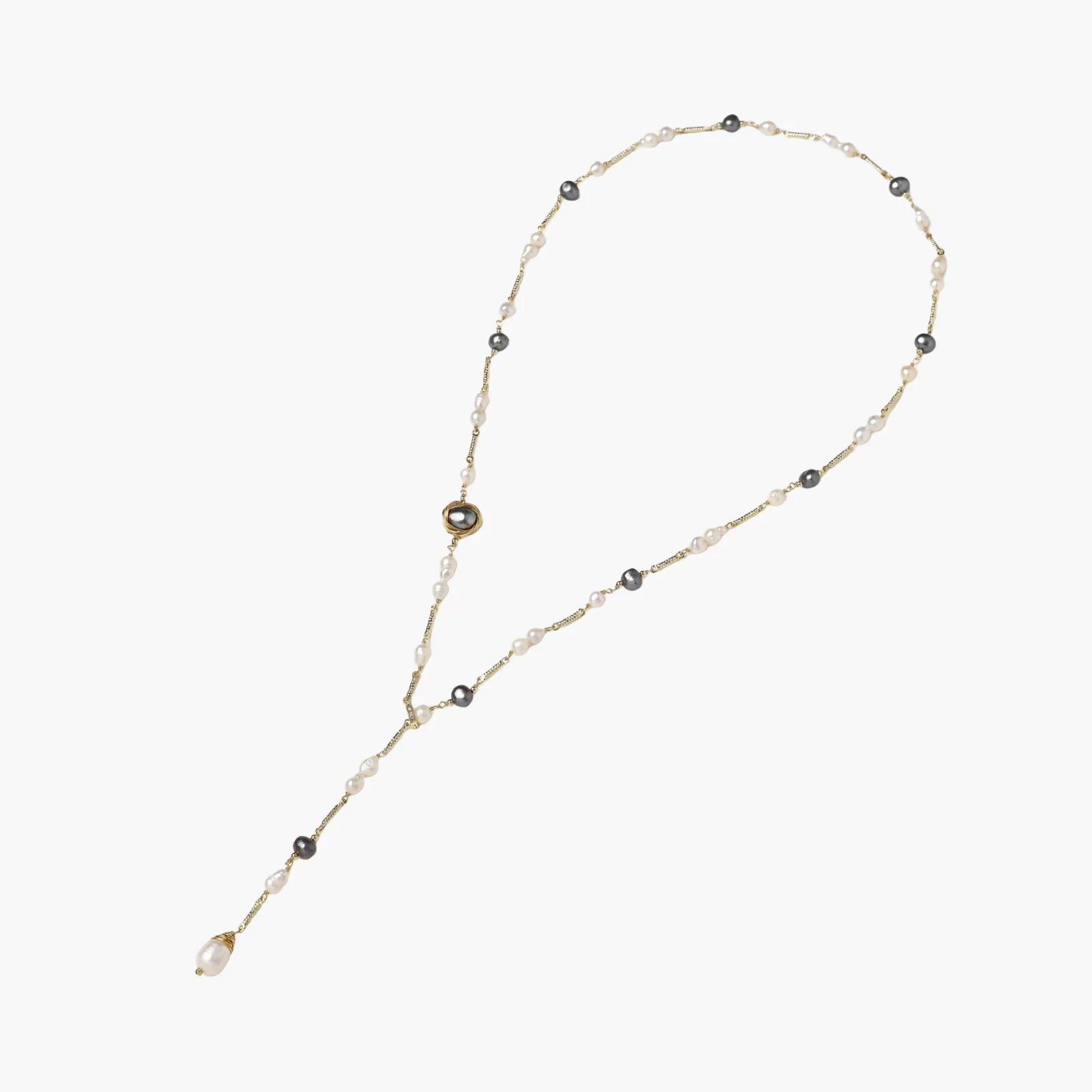 Y-shaped gold-plated necklace with white and gray freshwater pearls on cream background, showing adjustable drop design.