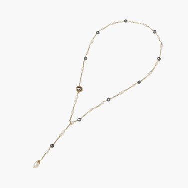Y-shaped gold-plated necklace with white and gray freshwater pearls on cream background, showing adjustable drop design.