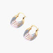 Gold hoop earrings with gradient blue-to-pink enamel in ribbed fan design on beige background