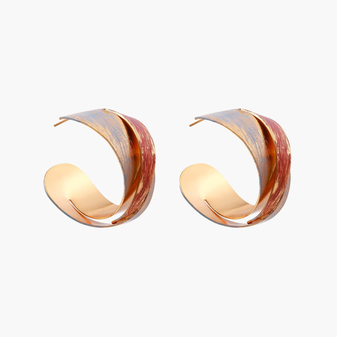 Sculptural gold-plated hoop earrings with diagonal purple and coral enamel stripes in twisted ribbon design