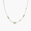 Delicate pearl necklace with pale green serpentine jade centerpiece and colorful agate beads on cream background