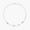 Delicate pearl necklace with pale green serpentine jade centerpiece and colorful agate beads on cream background