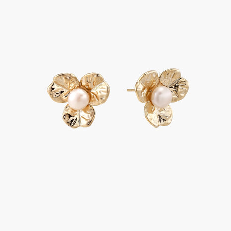 Gold-plated flower stud earrings with textured petals and centered freshwater pearl on beige background