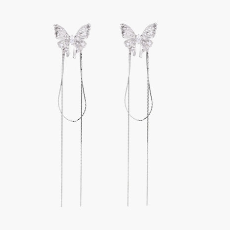 Pair of silver threader earrings with crystal butterfly tops and long chain drops on cream background.