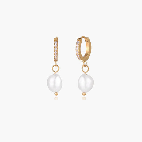 Gold huggie hoop earrings with pavé crystals and white freshwater pearl drops on cream background
