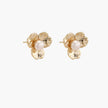 Gold-plated flower stud earrings with textured petals and centered freshwater pearl on beige background