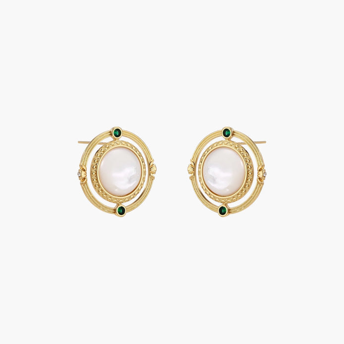 Circular gold stud earrings with iridescent mother-of-pearl center and green zirconia accents on cream background.
