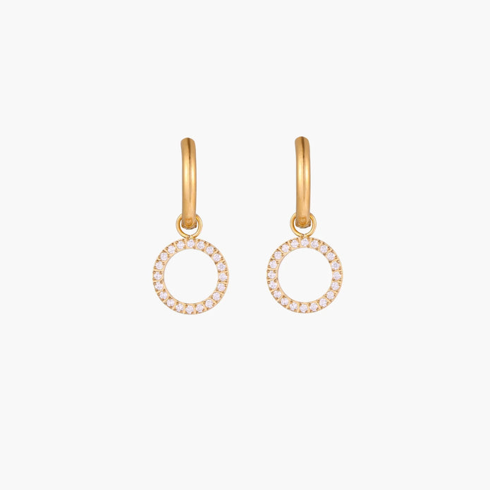 Gold-plated huggie hoop earrings with CZ-studded open circle charms on beige background