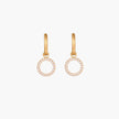 Gold-plated huggie hoop earrings with CZ-studded open circle charms on beige background