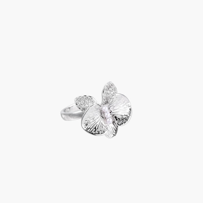 Silver-toned orchid ring with textured petals, pearl center accents, and sparkling zirconia stones on white background.