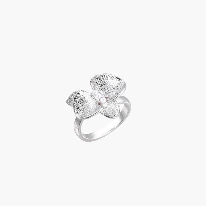 Silver-toned orchid ring with textured petals, pearl center accents, and sparkling zirconia stones on white background.
