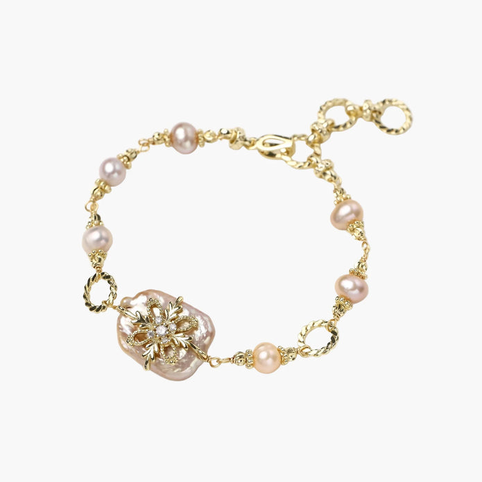 Gold-plated bracelet with pink baroque pearl centerpiece, floral connector, and freshwater pearls