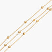 Three-strand gold-plated bracelet with clustered ball beads and adjustable clasp on cream background