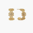 Gold hoop earrings with intricate three-dimensional floral filigree pattern in 14K gold plated brass on cream background