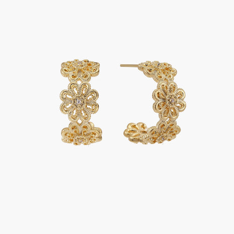 Gold hoop earrings with intricate three-dimensional floral filigree pattern in 14K gold plated brass on cream background