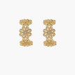 Gold hoop earrings with intricate three-dimensional floral filigree pattern in 14K gold plated brass on cream background