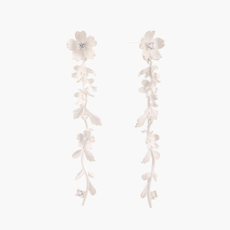 Long sterling silver drop earrings with delicate floral vine design and crystal accents on white background