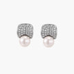 Curved pavé diamond studs in white gold-plated brass cradle lustrous freshwater pearls against cream background
