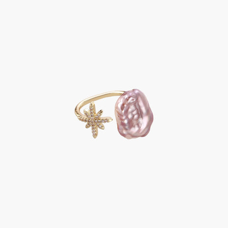 Adjustable gold ring with pink baroque freshwater pearl and crystal-studded star charm on white background