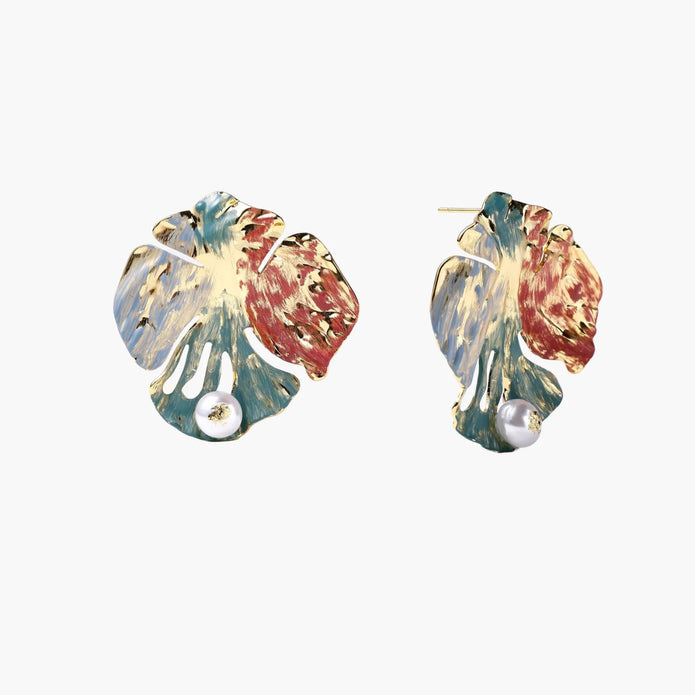 Artistic monstera-shaped earrings with teal, coral, and cream enamel brushstrokes, gold trim, and white pearl accent