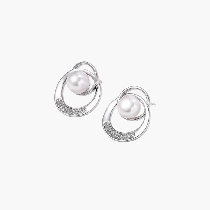 White gold-plated brass earrings with circular design, freshwater pearl center, and diamond accents