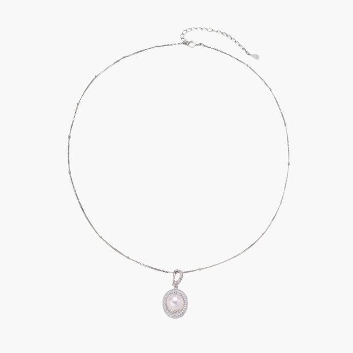 Oval sterling silver pendant with crystal halo surrounding a white freshwater pearl on delicate chain
