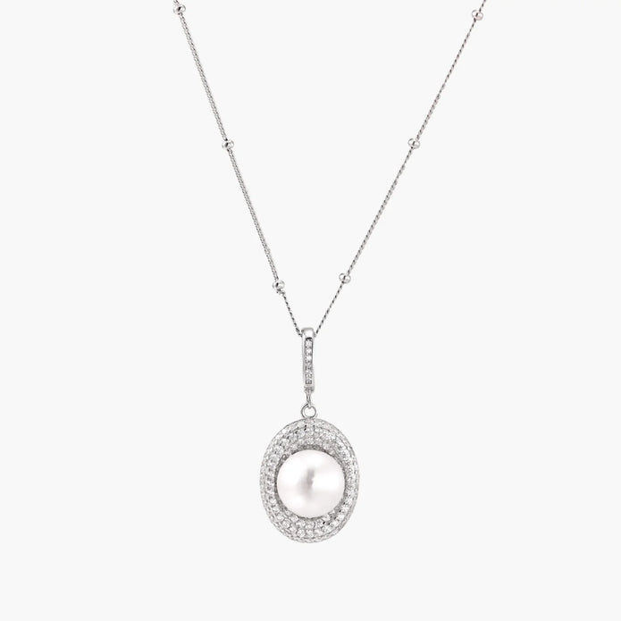 Oval sterling silver pendant with crystal halo surrounding a white freshwater pearl on delicate chain