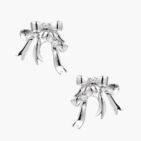Sculptural bow earrings in polished white gold plate with sparkling zirconia stones and flowing ribbon details