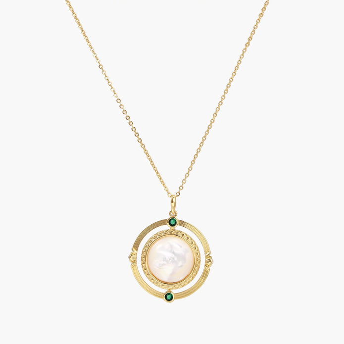 Gold pendant necklace with circular orbital design, iridescent mother-of-pearl center, and green zirconia accents