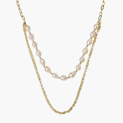 Layered gold chain necklace with organic baroque freshwater pearls and adjustable length on cream background