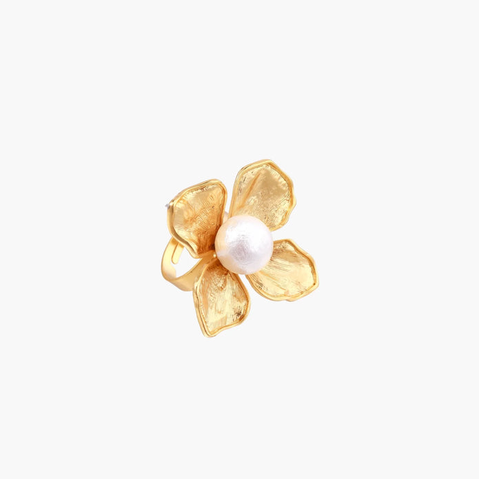 Gold-plated flower ring with textured petals and white cotton pearl center on cream background