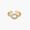 Gold-plated brass chain link ring with one oval CZ-pavé segment on cream background, adjustable cuff style.
