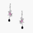 Silver-toned drop earrings with ornate rose design, pink zirconia center, and black teardrop stones on cream background