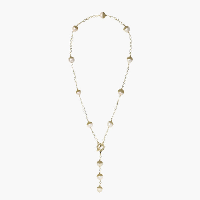 Gold-plated lariat necklace with baroque pearls and textured caps on cream background, showing adjustable Y-shaped design.