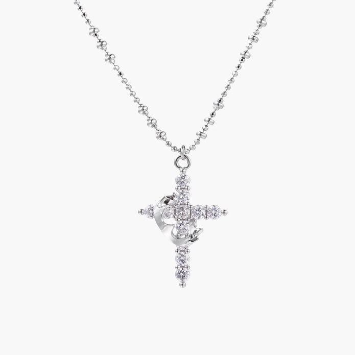 White gold-plated cross pendant adorned with sparkling zirconia stones and crescent moon accent on ball chain
