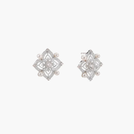 Ornate sterling silver stud earrings with mandala-inspired filigree pattern and four freshwater pearls on beige background